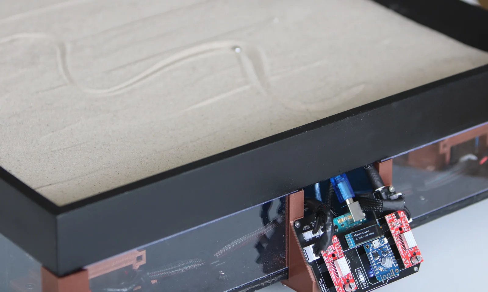 A drawing in the sand above the table’s visible control electronics.